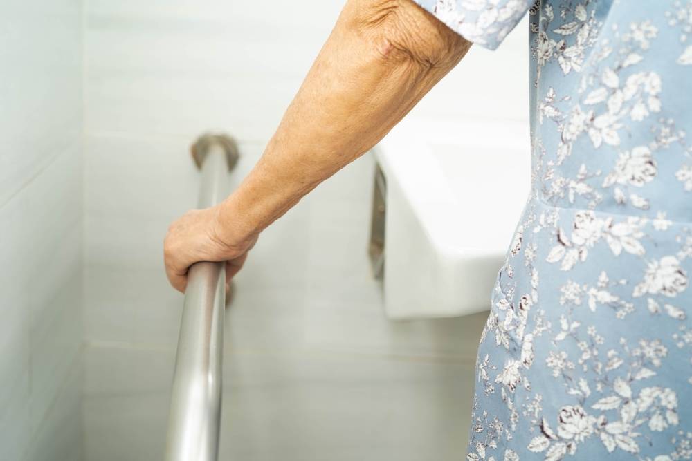 A bathroom handrail for an elderly woman.